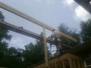 Carpenter setting a ridge beam over a new addition frame — Ice Dam Removal by Roofing Brothers in Fayette